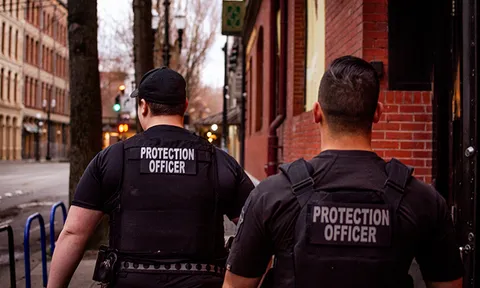 Two protection officers standing on a city street