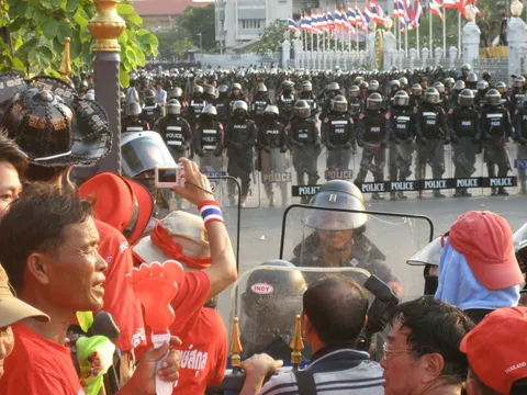 People in red shirts sitting on gray chairs during the daytime